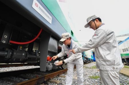 (miniature) Des employés examinent une locomotive électrique lourde intelligente à Zhuzhou